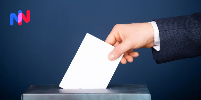 Une main glisse un bulletin de vote dans une urne