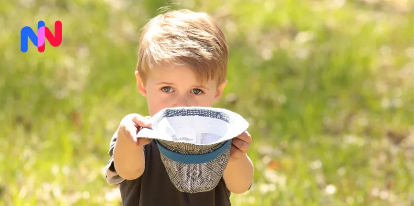 Jeune enfant tenant un chapeau dehors